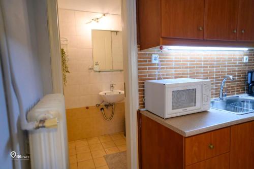 a kitchen with a sink and a microwave on a counter at 'Afrodite' Central Cozy Studio In Egaleo in Athens