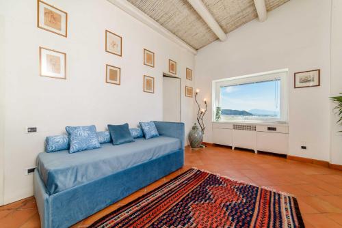 a living room with a blue couch and a window at Starhost - Villa il Poggio Amalfi Coast in Vietri