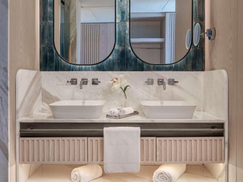 Swissotel Resort And Spa Cesme في تشيشمي: حمام مغسلتين ومرآة
