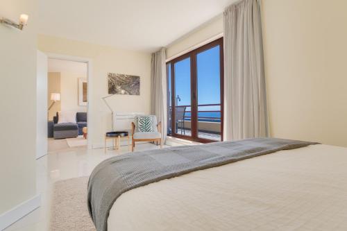a bedroom with a bed and a view of the ocean at Funchal Marina Bay in Funchal