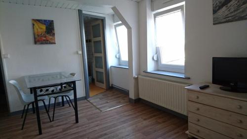 un salon avec une table et une télévision dans l'établissement Studio N°5 Boston Conciergerie Leroy, à Boulogne-sur-Mer