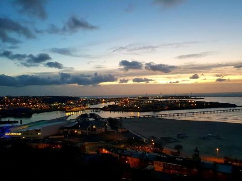 une vue d'une ville la nuit avec l'océan dans l'établissement Studio N°5 Boston Conciergerie Leroy, à Boulogne-sur-Mer