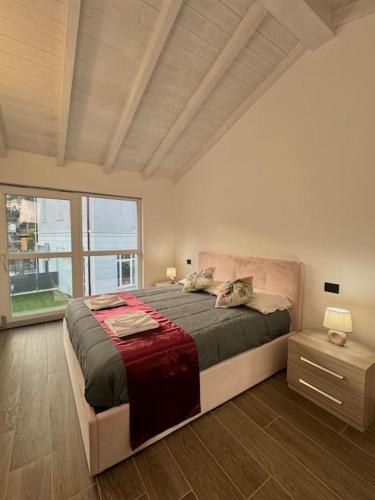 1 dormitorio con cama grande y ventana grande en Apt. Virgo - Oasi di Menaggio, en Menaggio