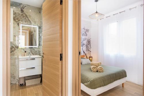 罗克布吕讷-卡普马丹ORCHIDÉES - SPLENDIDE 2 Pièces - PARKING - 50 m BORD DE MER的一间带床的卧室和一间带水槽的浴室