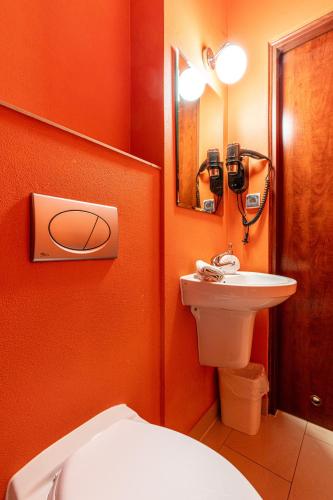 an orange bathroom with a toilet and a sink at Leśny Dworek Biały Dunajec in Zakopane