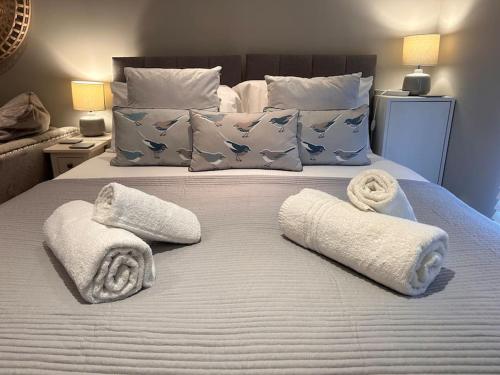 a bedroom with a bed with towels and pillows at The Gatehouse, Bijou studio apartment - sleeps 2 in Easingwold