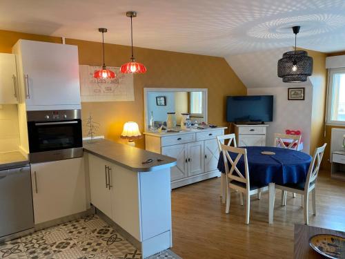 une cuisine avec une table et une salle à manger dans l'établissement Le St André Conciergerie Leroy, à Le Portel