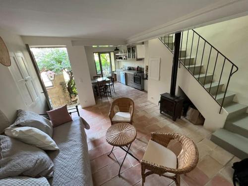 - un salon avec un canapé, des chaises et des escaliers dans l'établissement Très jolie maison de village, à Lourmarin