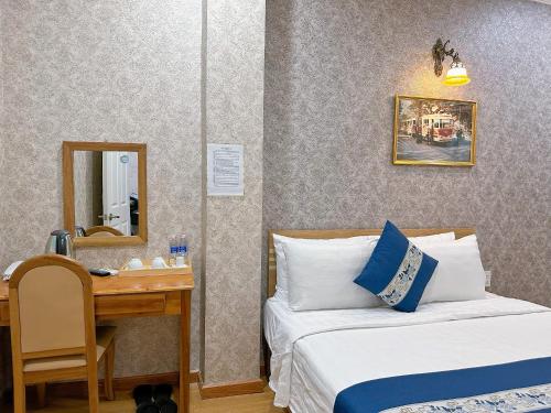 um quarto com 2 camas e uma secretária com um espelho em Tra My Hotel - SaiGon Center em Ho Chi Minh