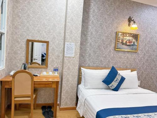Habitación con 2 camas y escritorio con espejo. en Tra My Hotel - SaiGon Center en Ho Chi Minh