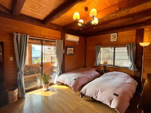 2 camas en una habitación con paredes de madera en beau lac biwako en Takashima