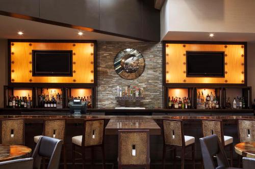 a bar in a restaurant with a bunch of bottles at Hilton Denver City Center in Denver