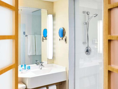 a bathroom with a sink and a shower at Novotel Toronto North York in Toronto