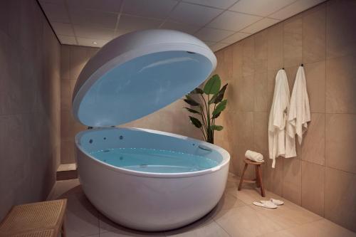 a bath tub in a bathroom with a toilet at Van der Valk Hotel Gilze-Tilburg in Tilburg