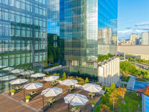 ソンナムにあるDoubleTree By Hilton Seoul Pangyo Residencesのテーブルと傘が備わる建物の空中風景