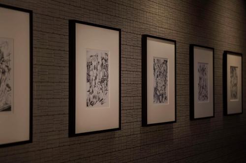 a row of framed drawings on a brick wall at Hilton Yokohama in Yokohama