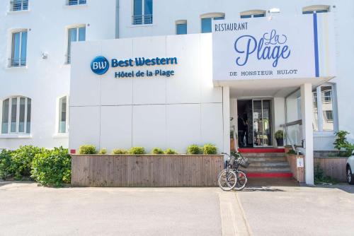 een fiets geparkeerd voor een gebouw bij Best Western Hotel De La Plage Saint Marc sur Mer in Saint-Nazaire