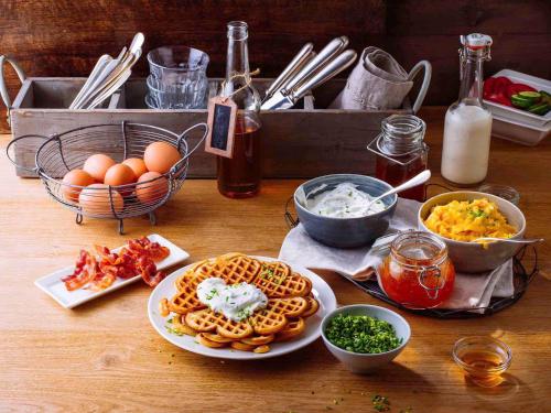 een tafel met wafels, eieren en ander voedsel bij ibis Issy les Moulineaux "Val de Seine" in Issy-les-Moulineaux