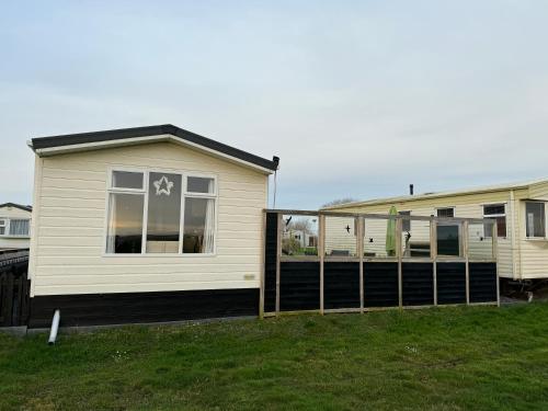a house with a fence in front of it at Prachtig chalet de ZEE STER in Westerland