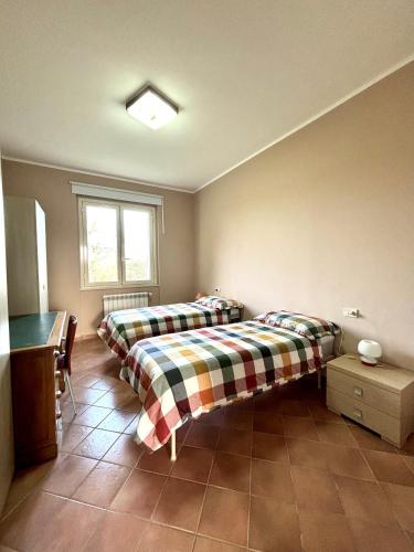 a bedroom with two beds and a window at TENUTA FATTORE in Santa Maria Imbaro