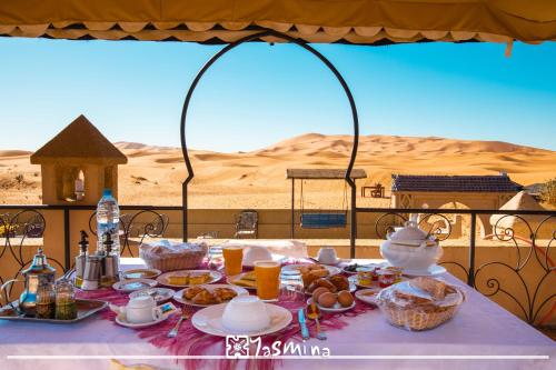 a table with food on it in the desert at Kasbah Yasmina Hotel in Lac Yasmins