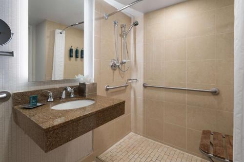 La salle de bains est pourvue d'un lavabo et d'une douche. dans l'établissement DoubleTree By Hilton Baltimore North Pikesville, à Pikesville