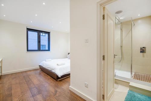 a white bedroom with a bed and a shower at Central 2 Bed Maissonette in London