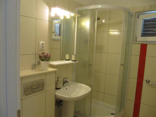 a bathroom with a sink and a shower at Villa Falcon in Podaca