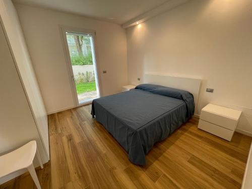 sypialnia z łóżkiem i dużym oknem w obiekcie Marina Dream Beach Apartments with Sea View Terrace - Agenzia Cocal w Caorle