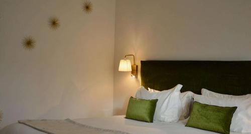 ein Schlafzimmer mit einem Bett mit zwei grünen Kissen in der Unterkunft Best Western Sévan Parc Hôtel in Pertuis
