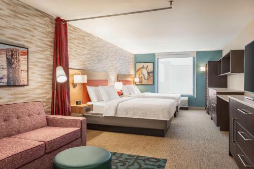 Habitación de hotel con cama y sofá en Home2 Suites By Hilton Cheyenne, en Cheyenne