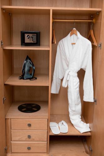 a wardrobe with a white robe and white shoes at Assiut Cement Hotel in Asyut