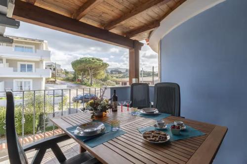 una mesa de madera con comida en la parte superior de un balcón en SHR Residence Valledoria Int 25, en Codaruina