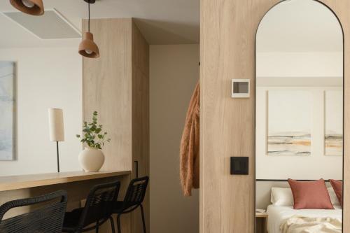 a bedroom with a bed and a desk and a mirror at Líbere Bilbao Ledesma in Bilbao