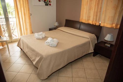 a bedroom with a bed with two towels on it at VILLA LIBECCIO appartment with shared swimming pool, at 200 meters from the beach, solarium and private parking in Avola