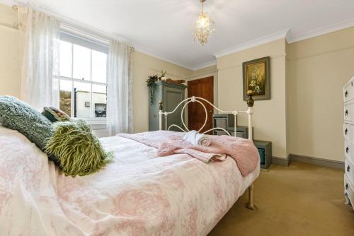 a bedroom with a bed with a pink blanket at Victorian cottage in Brixton! in London