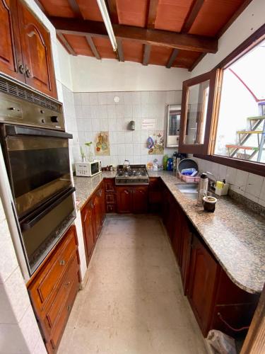 cocina grande con armarios de madera y horno grande en Esperanto hostel en Salta