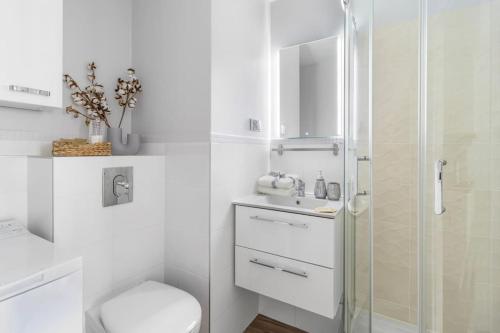 a white bathroom with a toilet and a shower at Downtown Oasis on foot to Central station parking metro smartTv WiFi in Warsaw