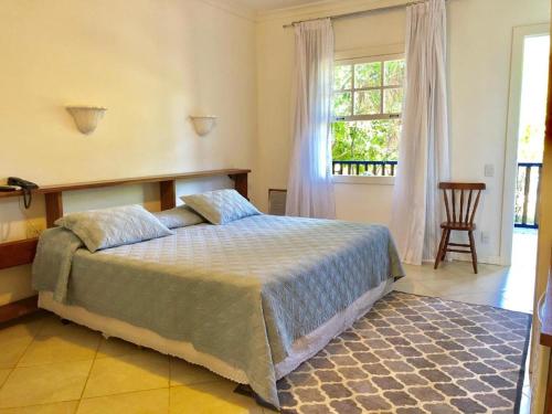 1 dormitorio con cama y ventana grande en Hotel Fazenda Florença, en Conservatória