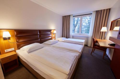 a hotel room with two beds and a window at Hotel Bredeney in Essen