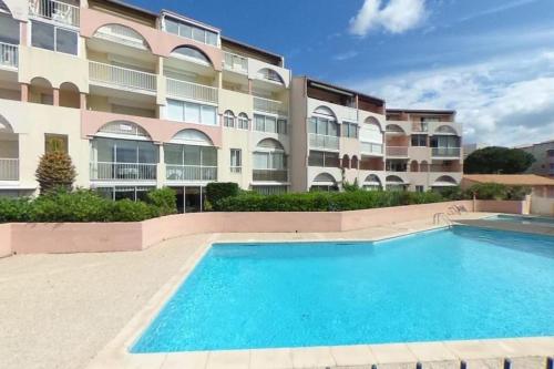 - une piscine en face d'un immeuble dans l'établissement T2 - Les pieds dans le sables en toutes saisons 5 couchages - climatisation - parking privée - piscine - situation optimum et rare - Amoureva - Plage Richelieu- Cap d'Agde, au Cap d'Agde