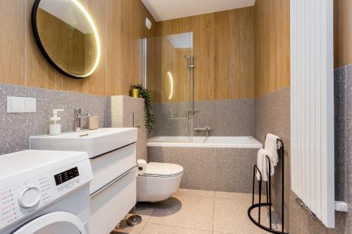 een badkamer met een wastafel, een toilet en een bad bij Złota Łąka Cosy Apartment in Gdańsk