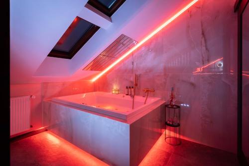 a white bathroom with a tub with red lights at Exclusive BDSM Apartment Kraków - ADULTS ONLY in Krakow