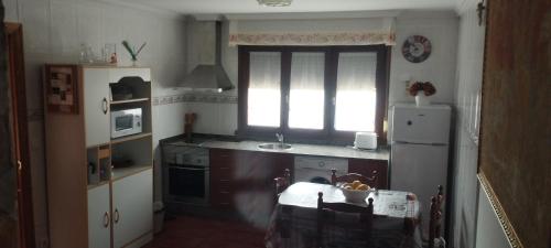 a kitchen with a refrigerator and a table in it at Mar del Norte in Salamir