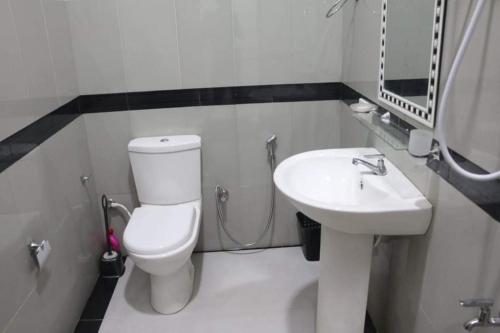 een badkamer met een wit toilet en een wastafel bij Sahasna Guest House in Diyatalawa