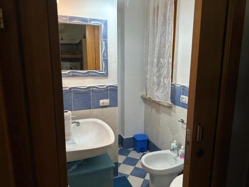 un bagno blu e bianco con lavandino e servizi igienici di New Residence 