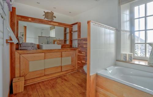 ein Badezimmer mit einer Badewanne, einem Waschbecken und einem Spiegel in der Unterkunft 3 Bedroom Lovely Home In Appeville in Appeville