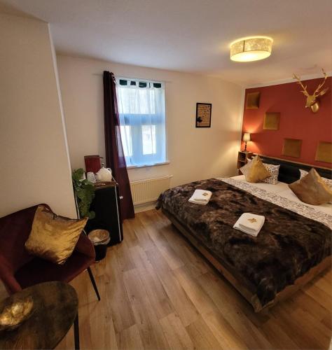 a bedroom with a large bed and a chair at Pension Am Stadtholz in Kröpelin