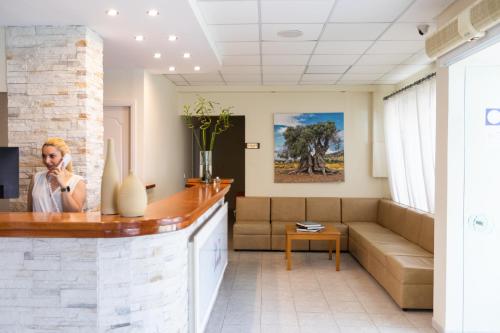a woman talking on a cell phone in a waiting room at Hotel Venetia in Perdhika