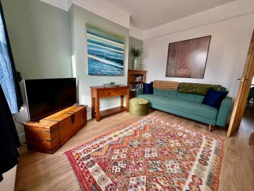 a living room with a blue couch and a flat screen tv at 3 bed terrace in central Cromer, close to beach in Cromer